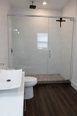 a bathroom with a sink a toilet and a shower