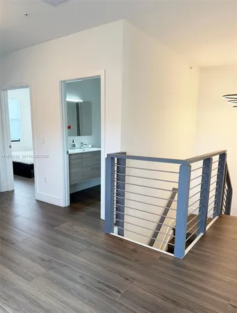 a view of a hallway with wooden floor and closet