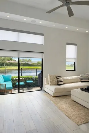 a living room with furniture and a floor to ceiling window