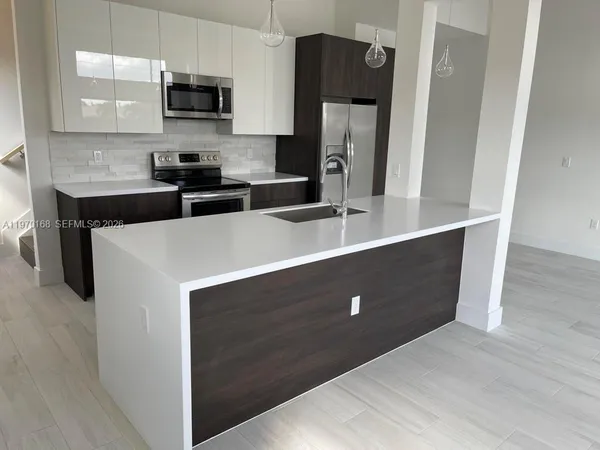 a kitchen with stainless steel appliances a refrigerator sink and microwave