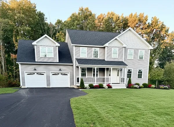 a front view of a house with a yard and trees