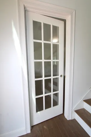 a view of an empty room with wooden floor and closet