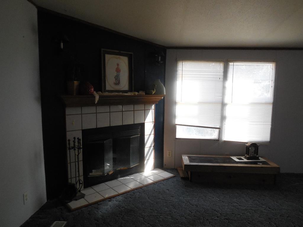 800 Melvin Street Ranger, TX 76470 - Photo 18 of 19 Carpeted living room with a tile fireplace
