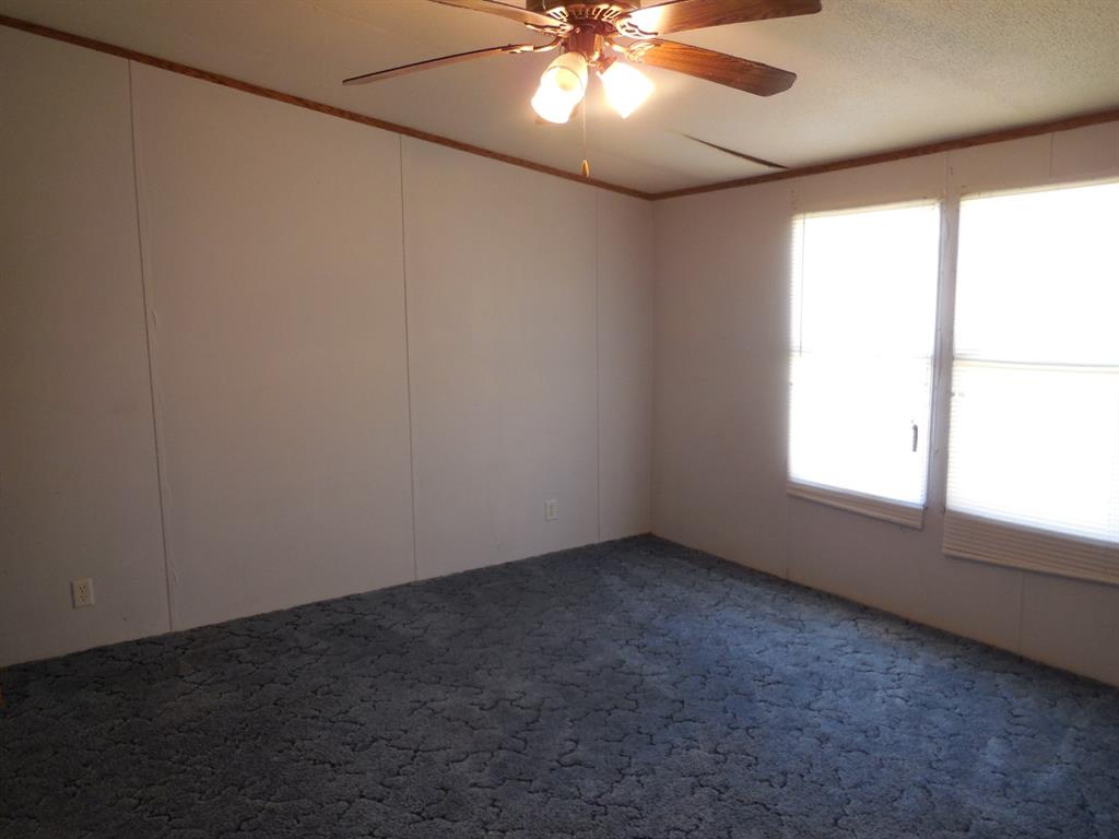 800 Melvin Street Ranger, TX 76470 - Photo 10 of 19 Carpeted empty room featuring a wealth of natural light and ceiling fan
