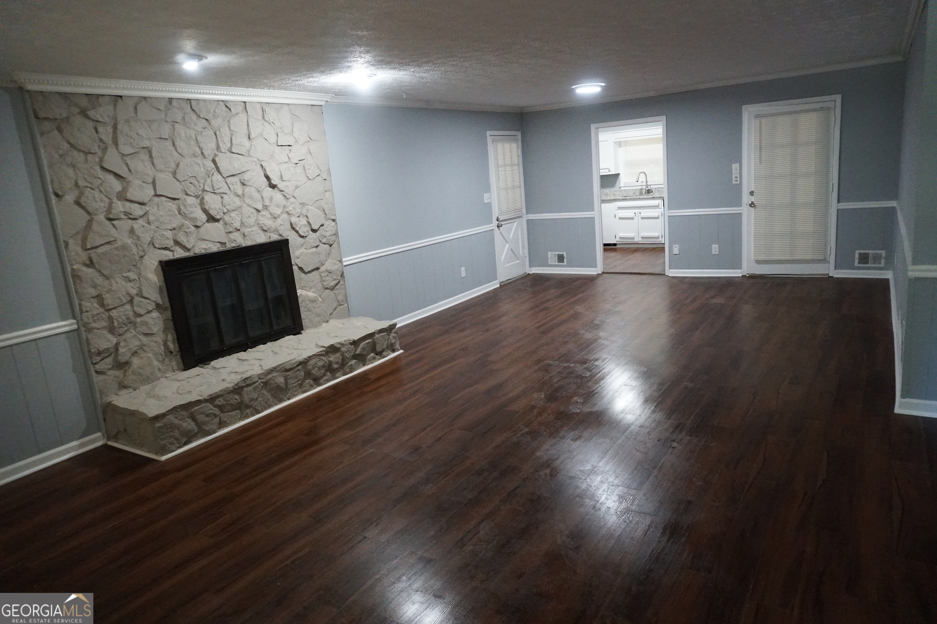 9243 Seminole Road Jonesboro, GA 30236 - Photo 4 of 40 an empty room with wooden floor fireplace and windows