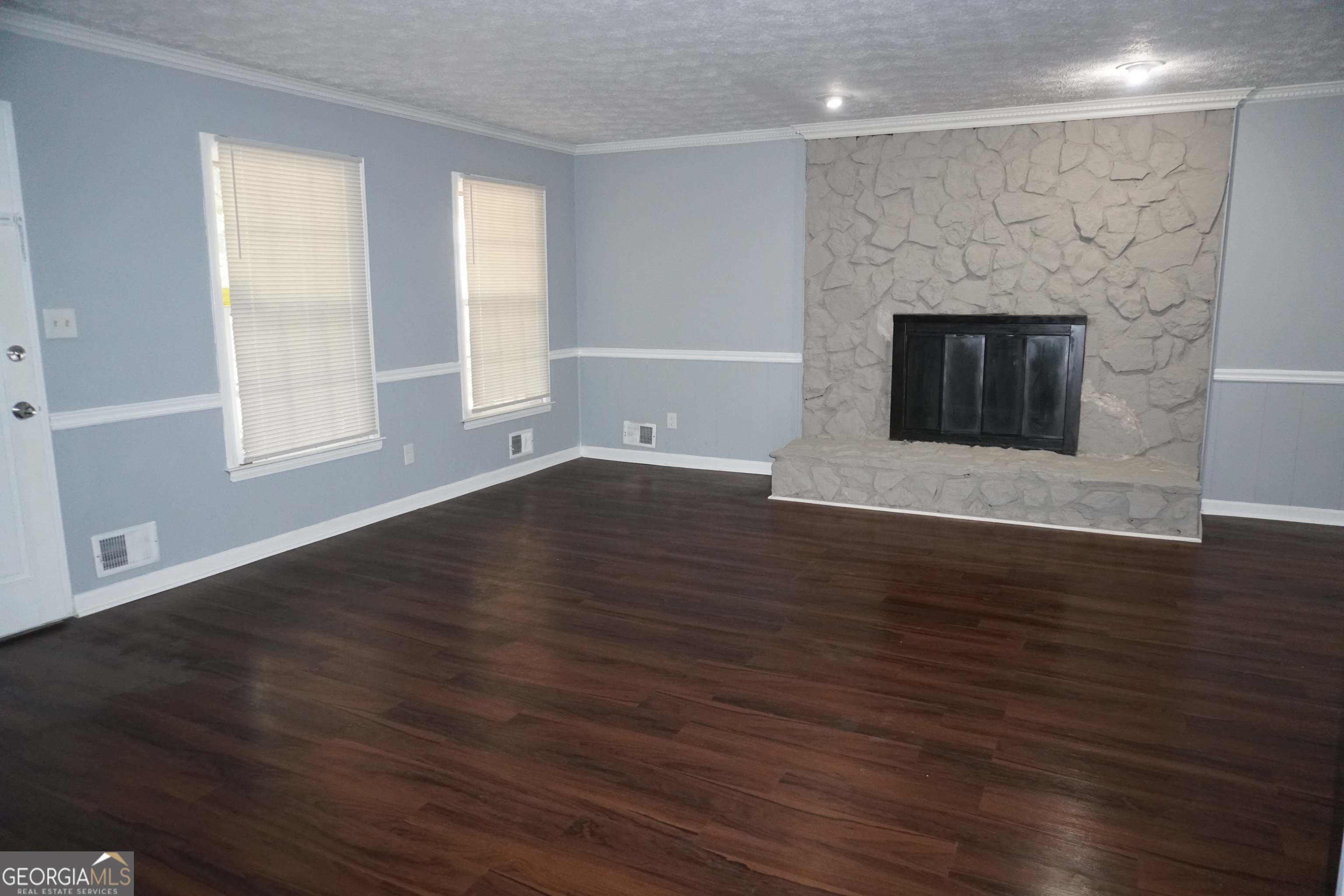9243 Seminole Road Jonesboro, GA 30236 - Photo 6 of 40 an empty room with wooden floor and fireplace