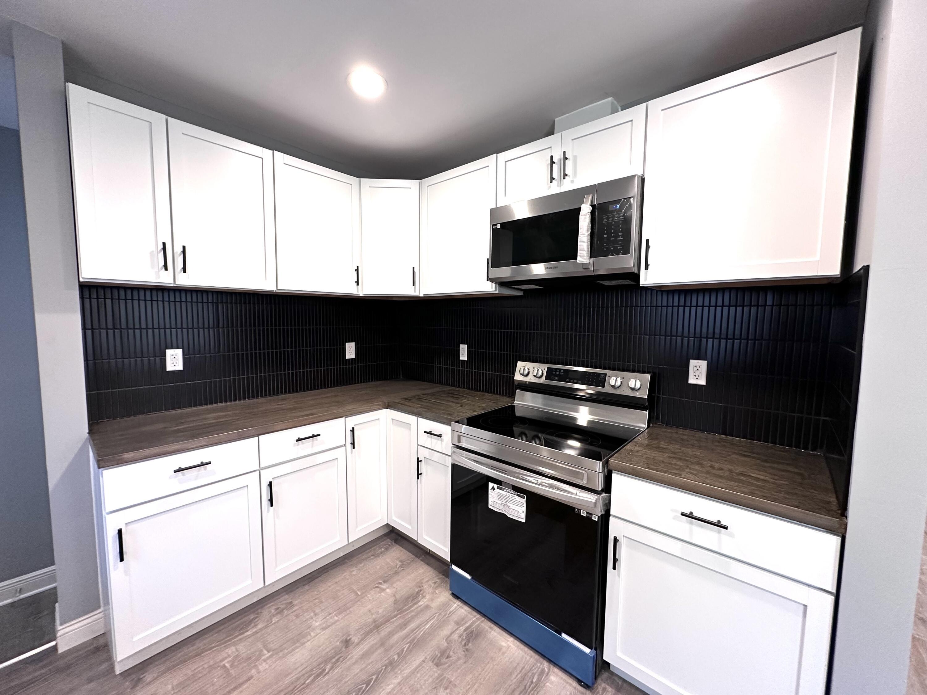 200 Taft Place Gary, IN 46404 - Photo 5 of 18 a kitchen with stainless steel appliances granite countertop a sink a stove a microwave a counter top and cabinets
