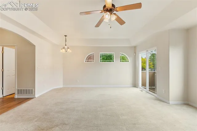 an empty room with fan and windows