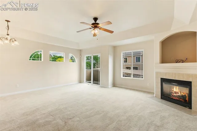 a view of an empty room with window and fireplace