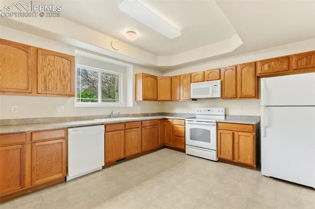 a kitchen with stainless steel appliances granite countertop a refrigerator sink and stove