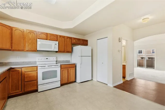 a kitchen with stainless steel appliances granite countertop a refrigerator and a stove top oven
