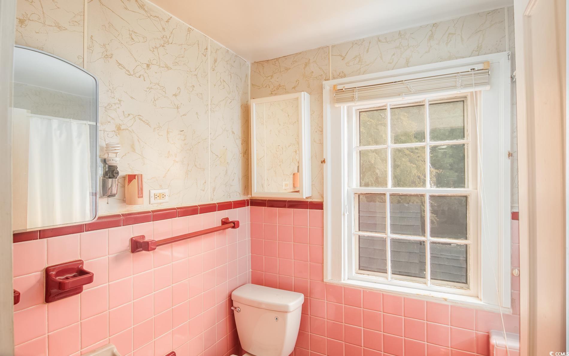 1010 Highmarket Street Georgetown, SC 29440 - Photo 20 of 32 Bathroom with wallpapered walls, a shower with shower curtain, tile walls, and a wainscoted wall