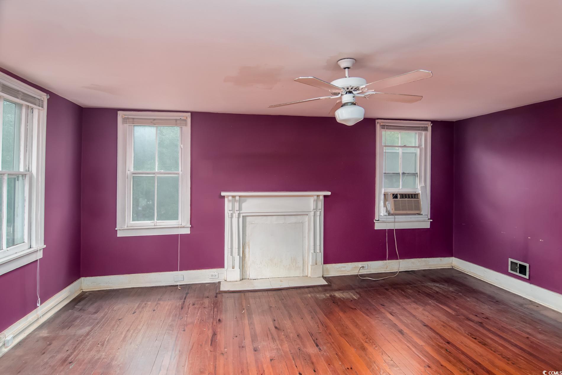 1010 Highmarket Street Georgetown, SC 29440 - Photo 23 of 32 Spare room featuring dark wood finished floors, a ceiling fan, cooling unit, and a fireplace