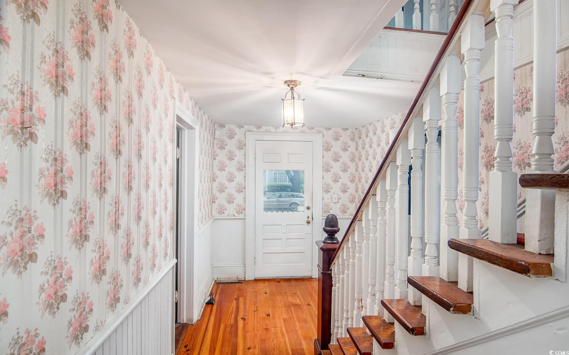 1010 Highmarket Street Georgetown, SC 29440 - Photo 6 of 32 Entryway featuring wallpapered walls, wainscoting, light wood-type flooring, and stairs