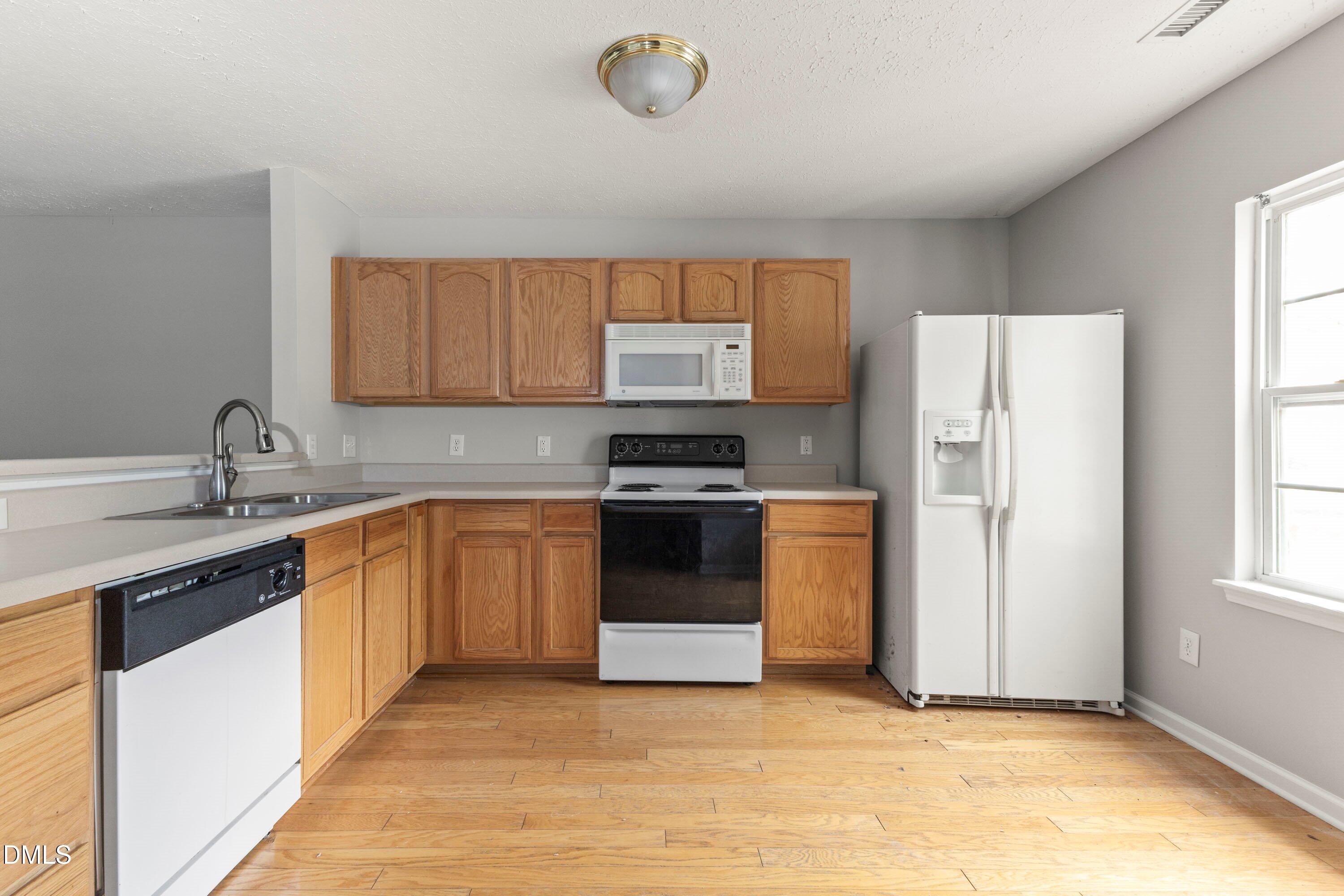 3358 Tarleton West Durham, NC 27713 - Photo 6 of 23 a kitchen with granite countertop a refrigerator and a sink