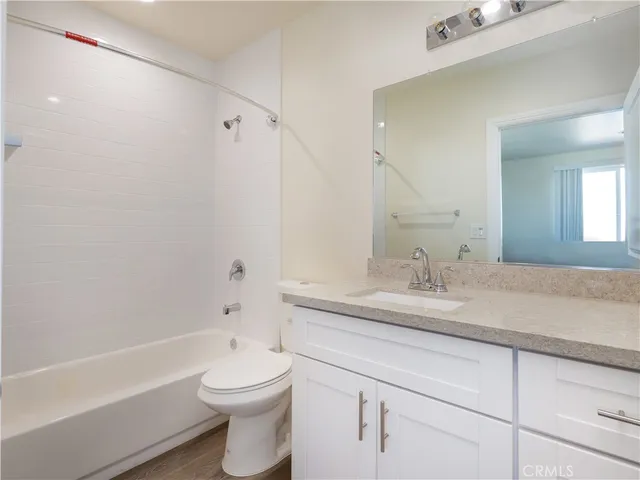 a bathroom with a granite countertop sink a toilet and a bathtub