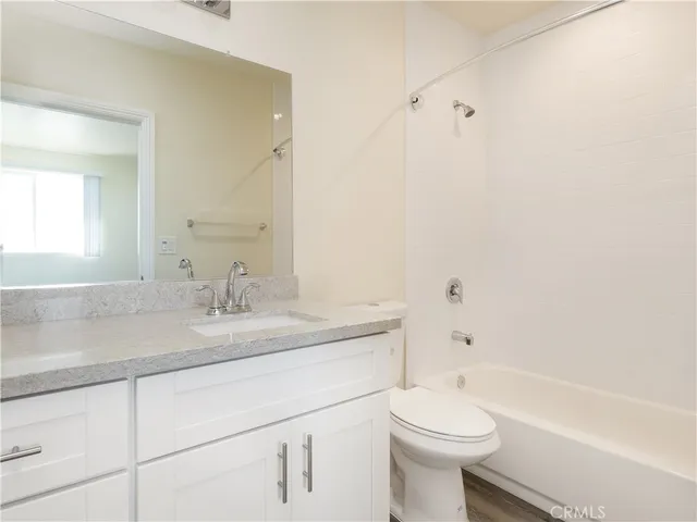 a bathroom with a granite countertop toilet a sink and a bathtub