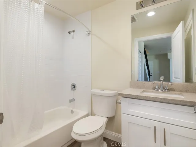 a bathroom with a granite countertop toilet a sink and a bathtub