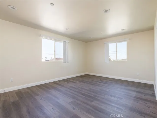 an empty room with wooden floor and window