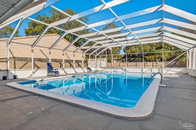 a view of swimming pool with a big yard and large trees