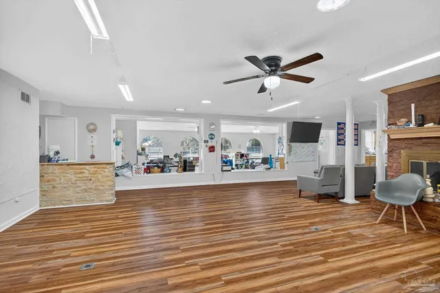 a view of a hallway with wooden floor and furniture