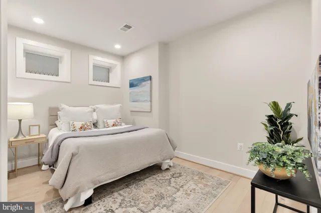 a bedroom with a bed plant and a window