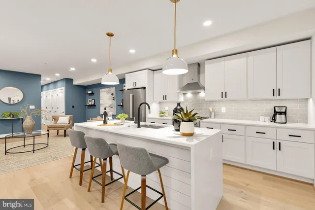 a kitchen with kitchen island white cabinets and stainless steel appliances