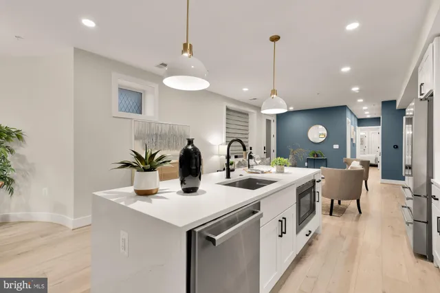 a kitchen with stainless steel appliances granite countertop a sink a stove top oven a counter space and cabinets