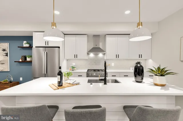 a kitchen with a sink a refrigerator and chairs
