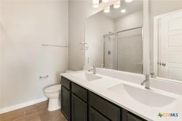 a bathroom with a sink a toilet and a mirror