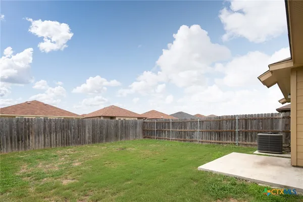 a view of a backyard with wooden fence