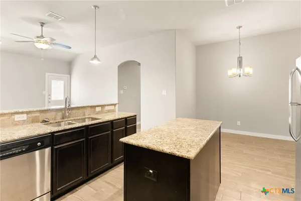 a kitchen with a sink a counter space and a refrigerator