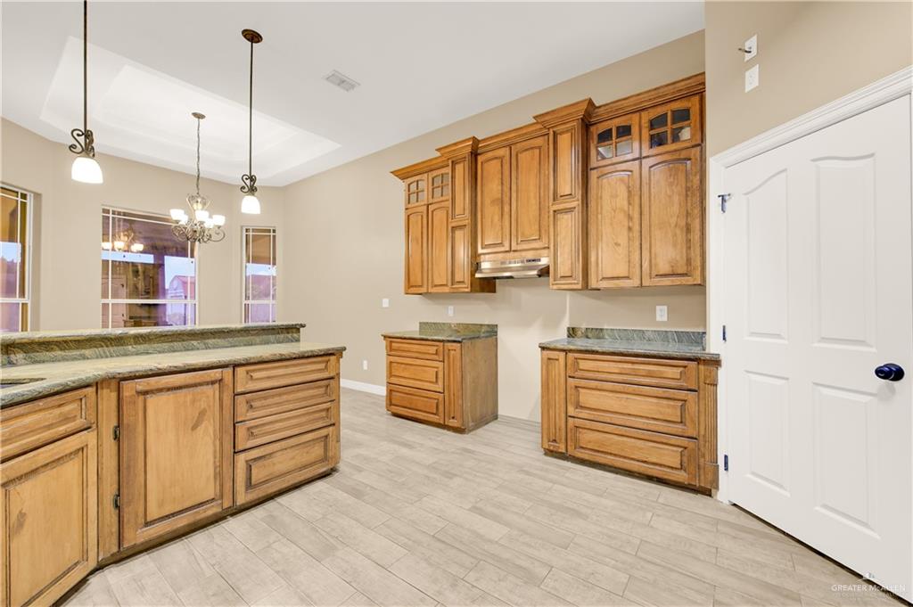 2005 Stuart Road Weslaco, TX 78599 - Photo 15 of 30 a large kitchen with stainless steel appliances granite countertop a stove a sink and a refrigerator with wooden floors