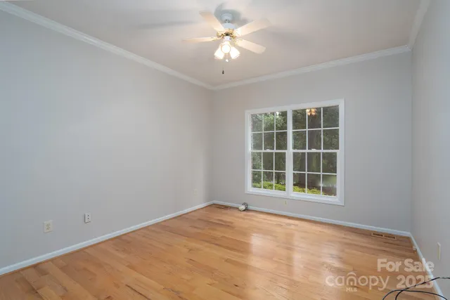 an empty room with a window and a fan