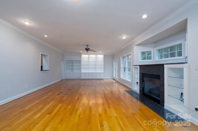 a view of empty room with wooden floor and fireplace