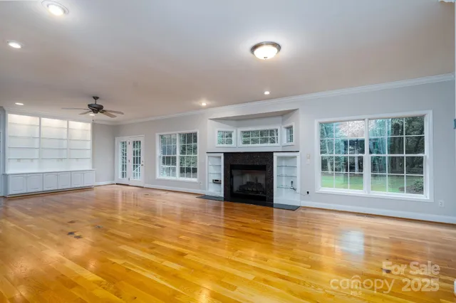 a view of an empty room with a fireplace and a large window