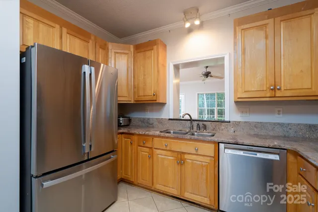 a kitchen with stainless steel appliances granite countertop a refrigerator and a sink