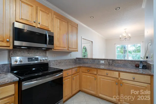 a kitchen with stainless steel appliances granite countertop white cabinets granite counter tops and a hard wood floors