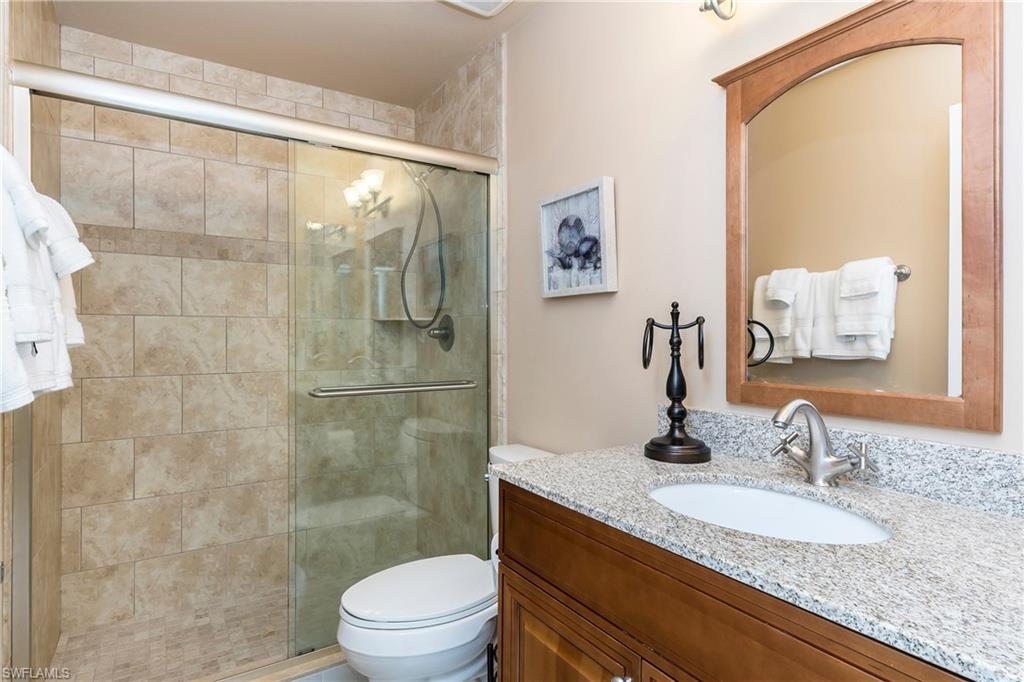 124 Versailles Circle Naples, FL 34112 - Photo 11 of 19 a bathroom with a granite countertop sink a toilet and shower