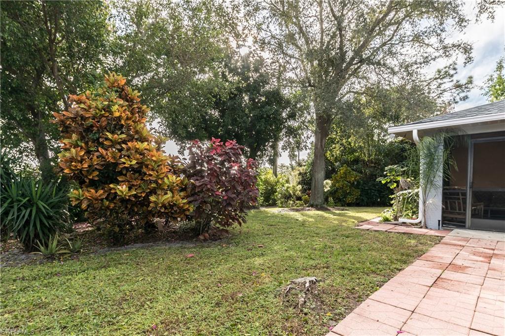 124 Versailles Circle Naples, FL 34112 - Photo 14 of 19 a view of a wooden house with a yard