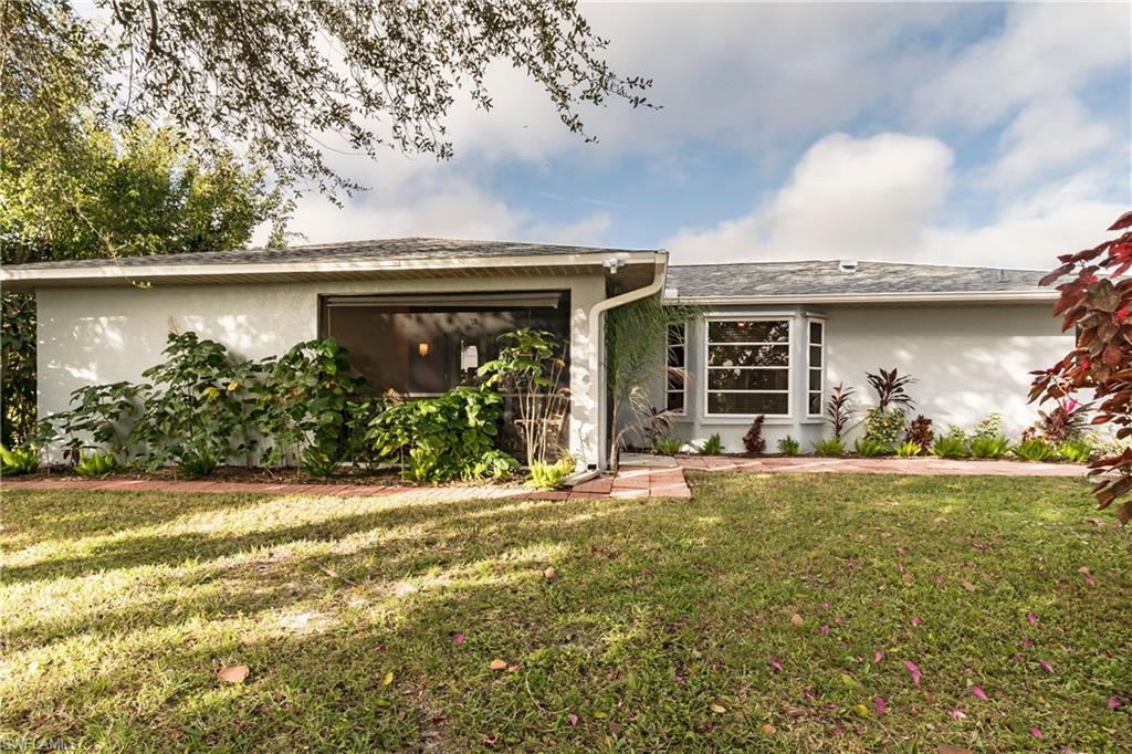 124 Versailles Circle Naples, FL 34112 - Photo 15 of 19 a front view of a house with garden