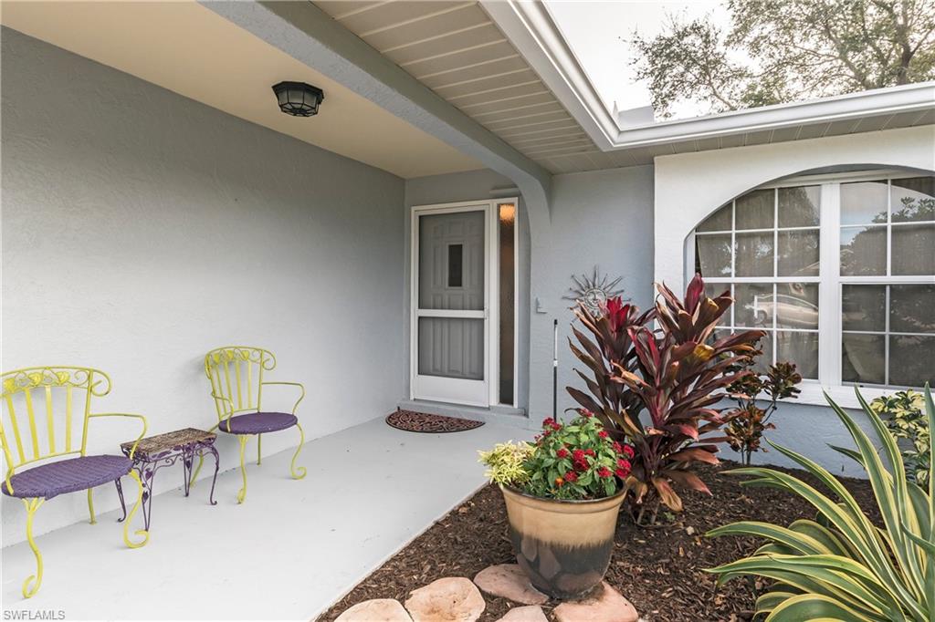 124 Versailles Circle Naples, FL 34112 - Photo 2 of 19 a view of a chair and table in backyard of the house