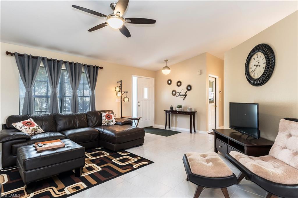 124 Versailles Circle Naples, FL 34112 - Photo 3 of 19 a living room with furniture a flat screen tv and a window