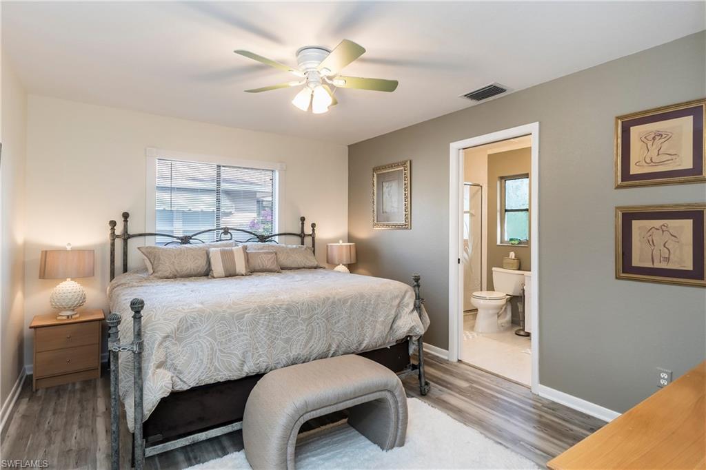 124 Versailles Circle Naples, FL 34112 - Photo 8 of 19 a bed room with a bed and a chandelier