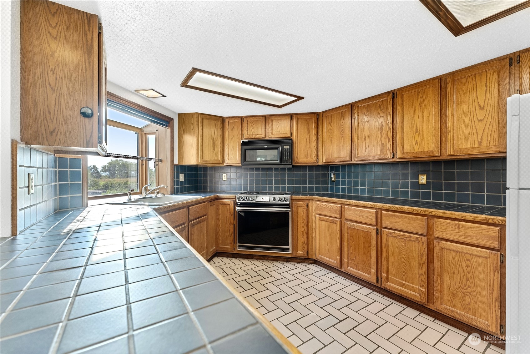 10 Pogue Road Okanogan, WA 98840 - Photo 14 of 40 a kitchen with granite countertop a stove a sink and a microwave