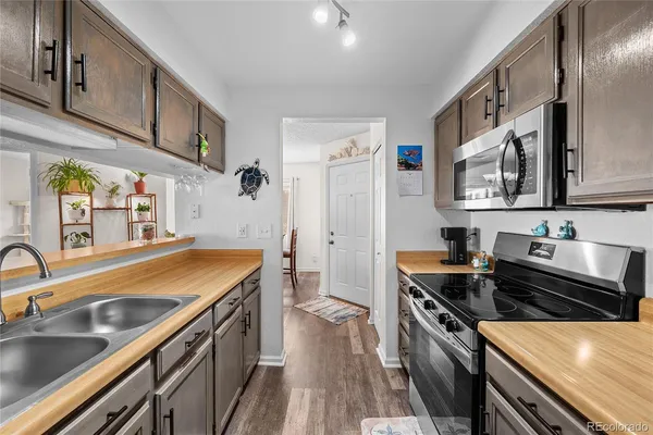a kitchen with stainless steel appliances a sink stove and cabinets
