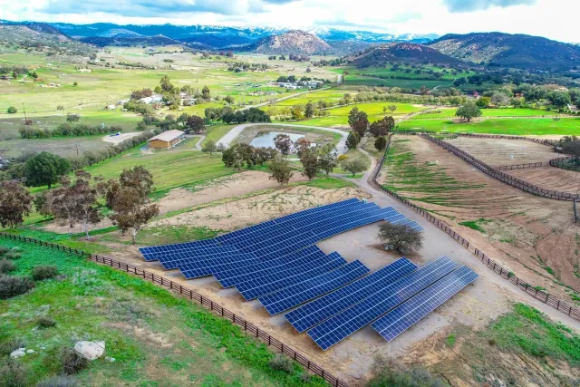 an aerial view of residential houses with outdoor space and trees