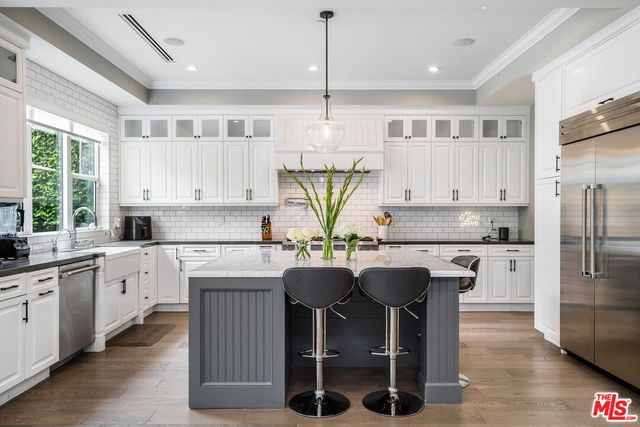 a kitchen with stainless steel appliances granite countertop a white cabinets and a chandelier