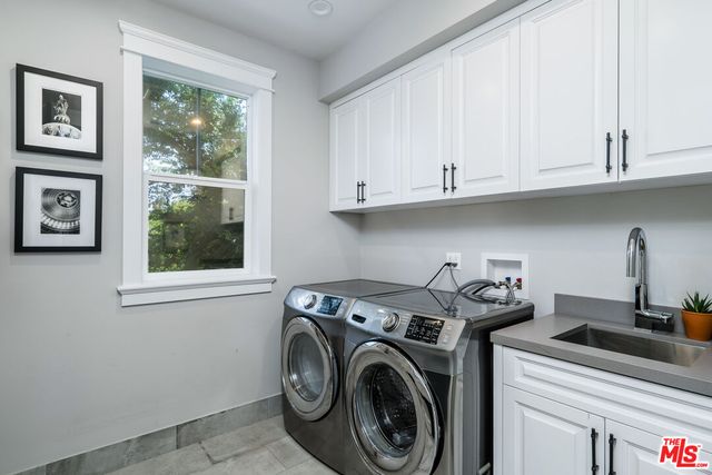 a utility room with sink dryer and washer