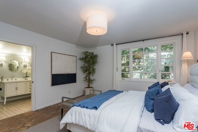 a bedroom with a large bed and a flat tv screen on dresser